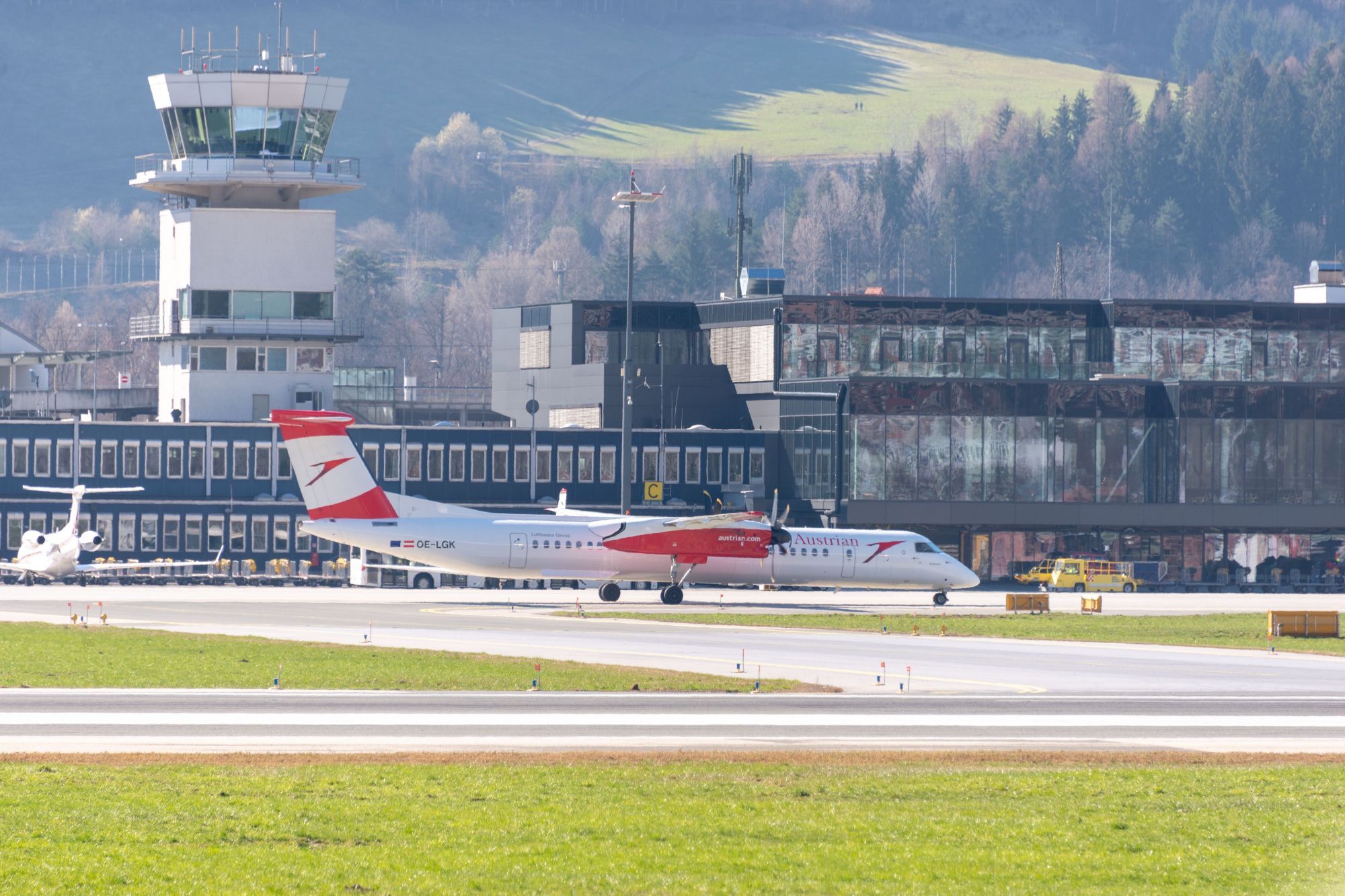 Innsbruck Luchthaven: terminal en toren met een Austrian-vliegtuig op het platform